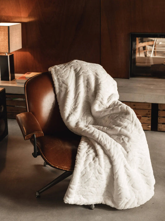 Plaid Ours Polaire Blanc posé sur un fauteuil