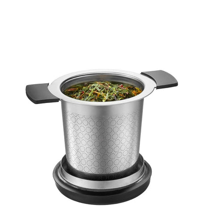 Filtre à thé savouro Gefu en acier inoxydable posé sur une tasse