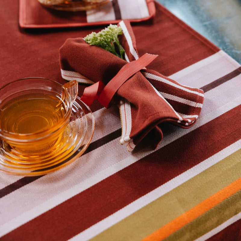 Jeté de table Artiga Sarron - rayures colorées sur fond rouge profond