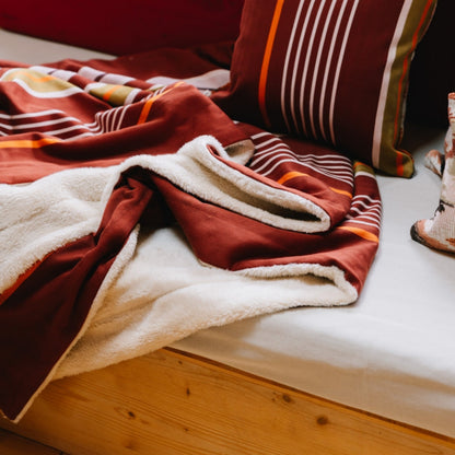 Plaid biface Artiga Sarron - rayures colorées sur fond rouge profond